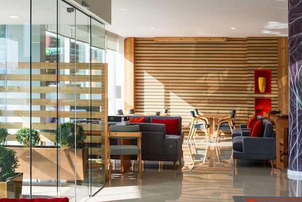 A modern interior with a wooden slat wall, glass partitions, and contemporary furniture.