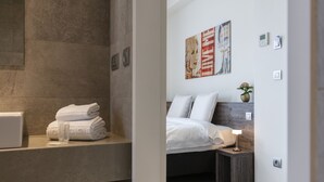 A modern bathroom with a large mirror, a towel rack, and a glass of water. - The Market by Parkhotel (Kortrijk)