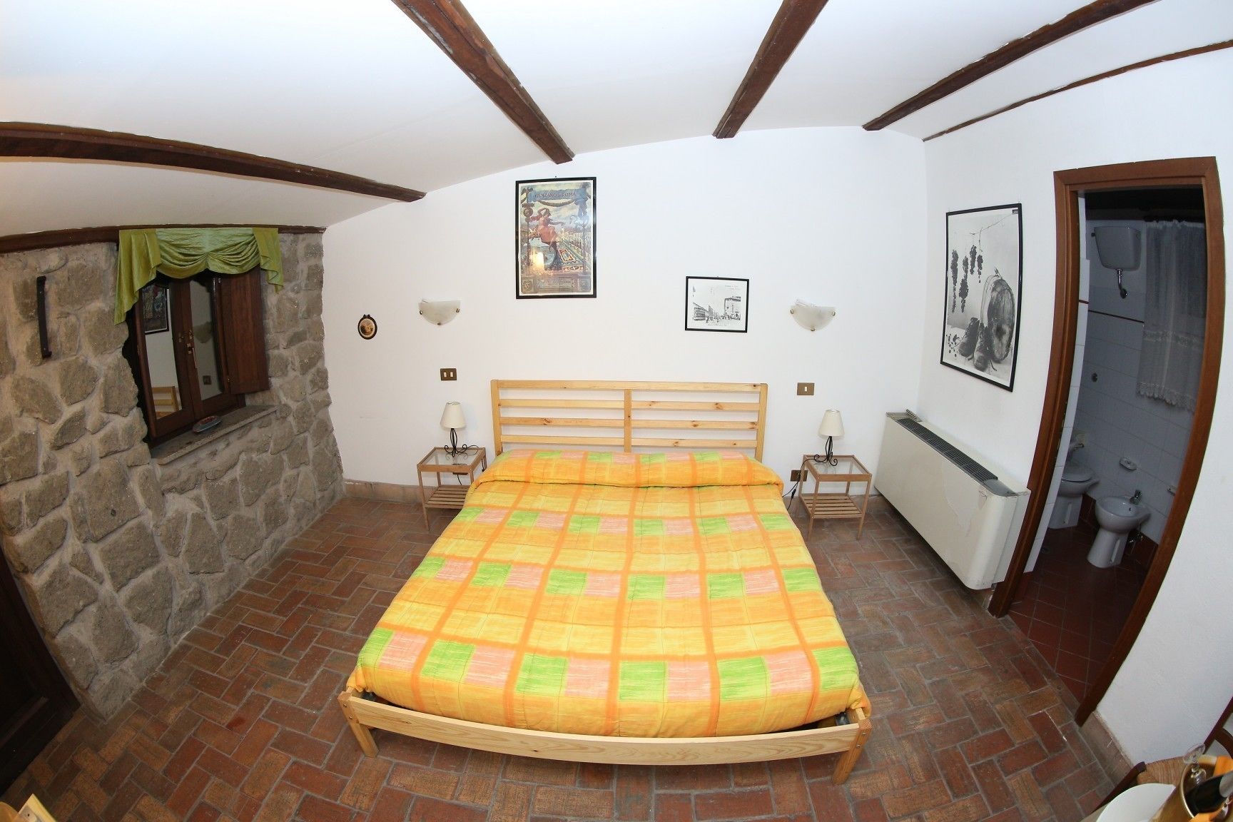 Une chambre à coucher avec un lit en bois, des murs en pierre et un sol carrelé.
