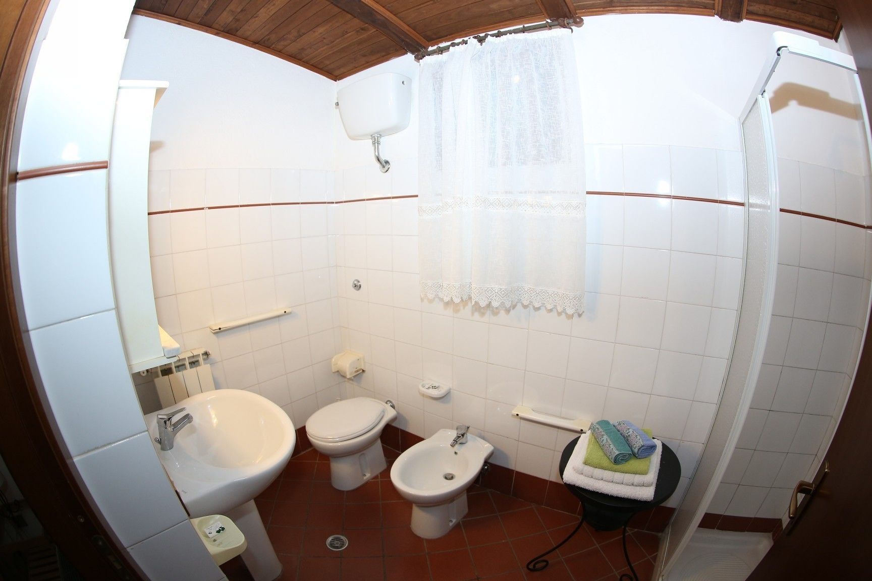Un bagno piccolo dotato di lavandino, due servizi igienici, un bidet e una doccia.