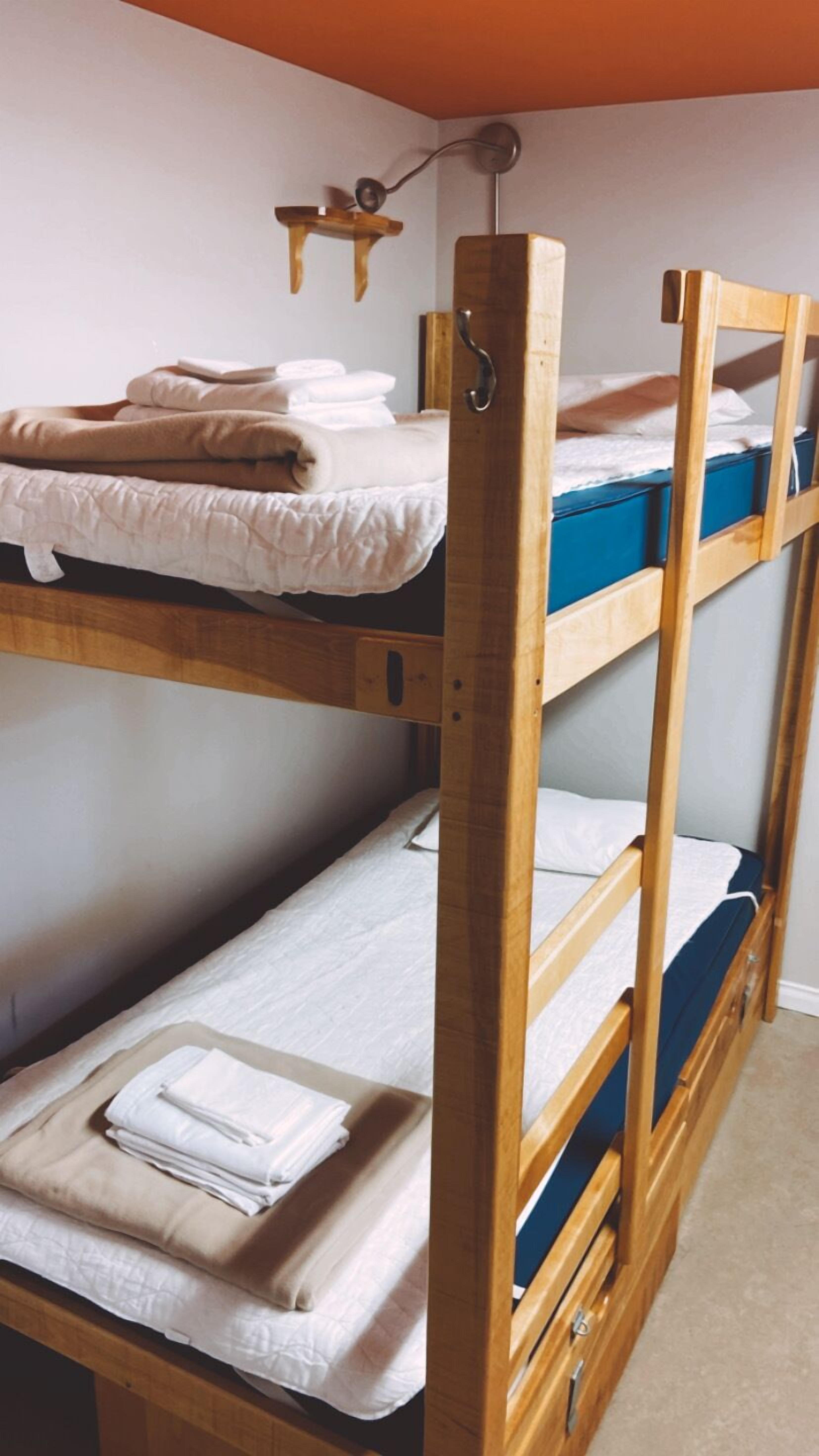 Una cama litera con tres niveles, cada uno con una almohada y un edredón doblado.