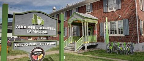 Un edificio con un cartel que dice "AUBERGE DE JEUNESSE LA MALBAIE RESTO-PUB TERRASE".