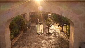 An arched stone pathway leading to a building with a lantern in the center. - Sa Vinya des Convent Agroturismo (Inca)