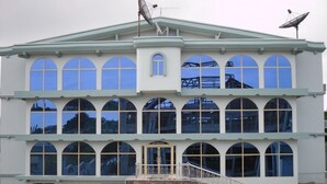 A building with a symmetrical facade, large arched windows, and a central entrance. - Senator Hotel (Kumasi)