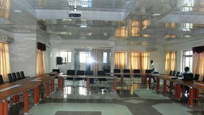 A conference room with a long table, chairs, and a projector. - Senator Hotel (Kumasi)