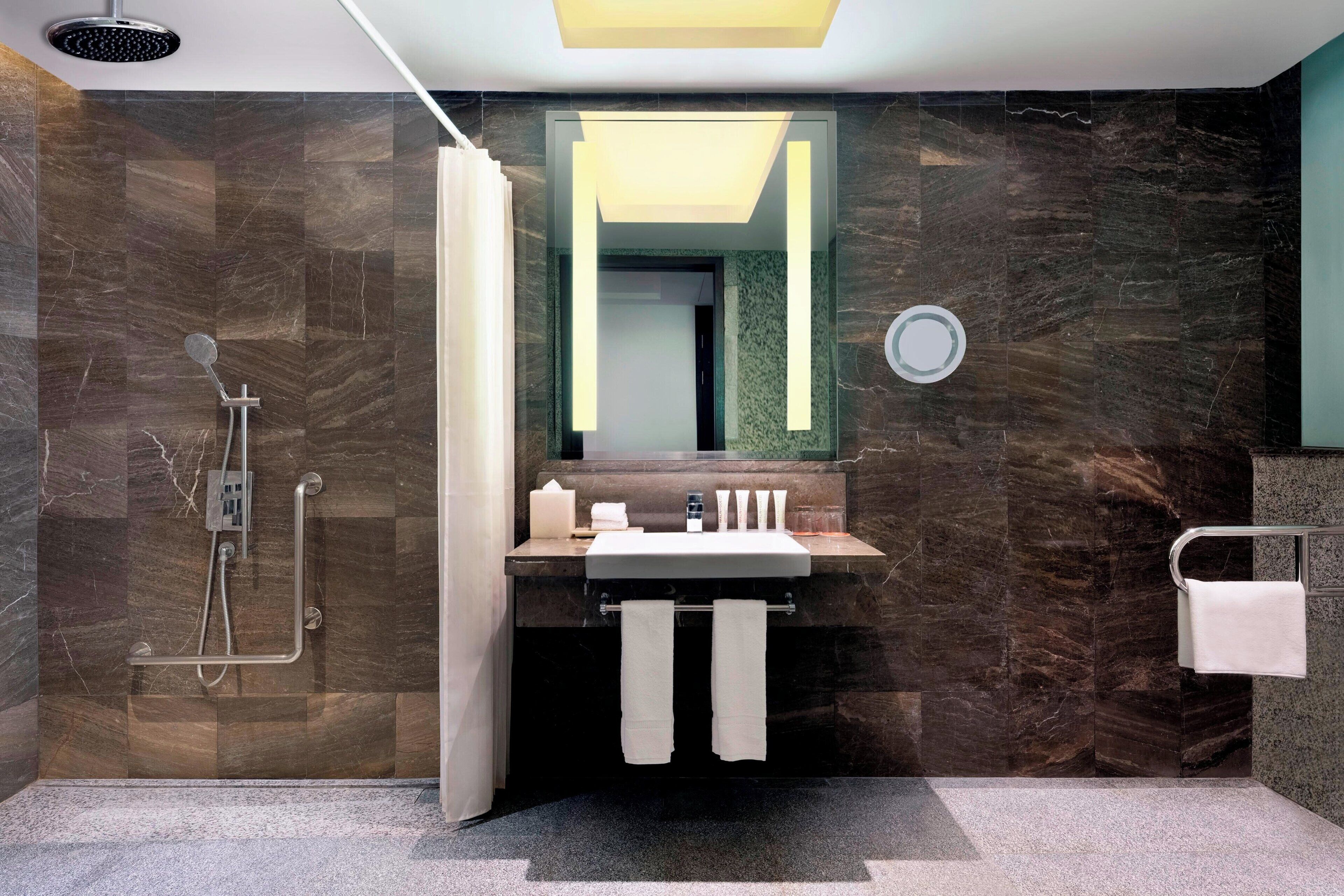 Un baño moderno con ducha, lavabo y espejo.