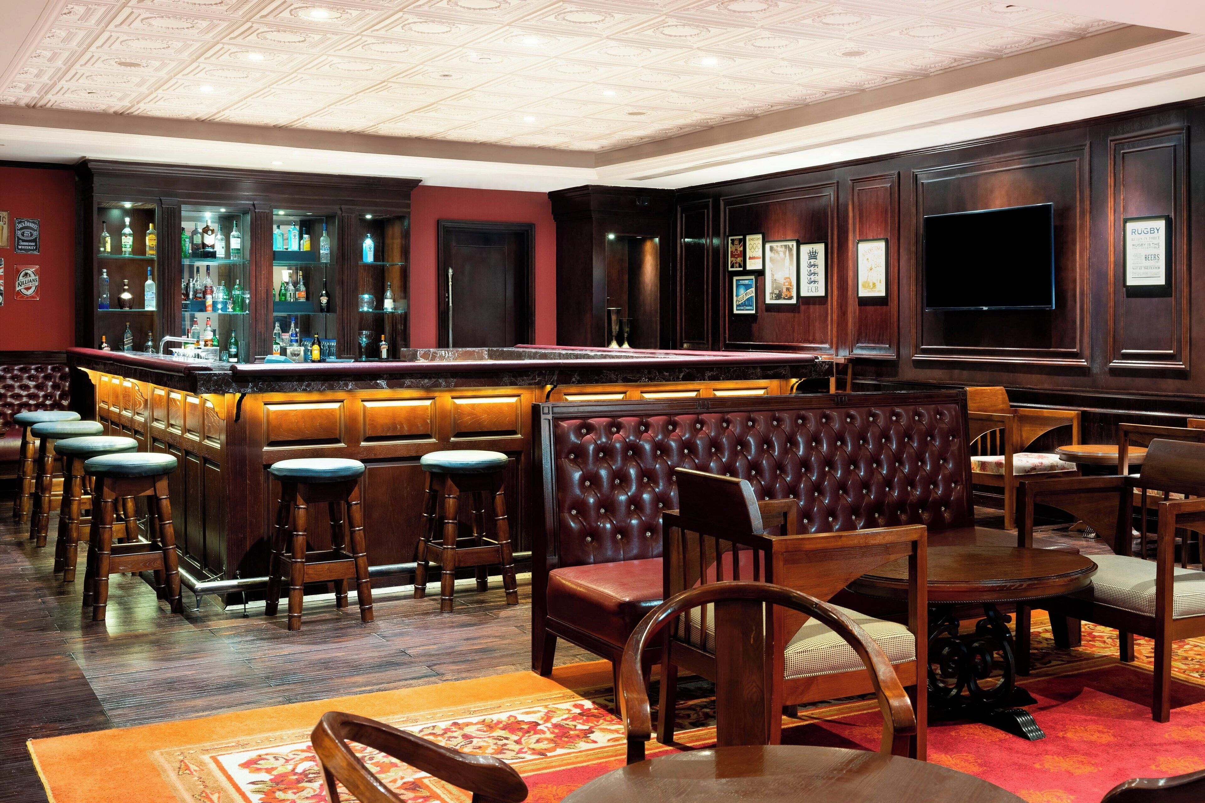 A bar area with a bar counter, stools, and seating.