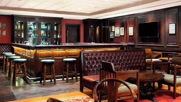 A bar area with a bar counter, stools, and seating.