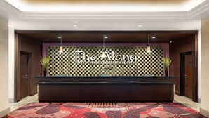 A reception area with a checkered wall design, a reception desk, and a patterned carpet. - The Alana Hotel & Conference Center Malioboro Yogyakarta by ASTON (Yogyakarta)
