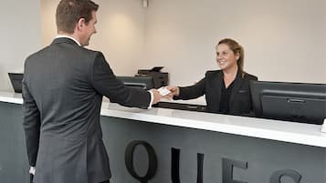 A reception desk with a man and a woman shaking hands.