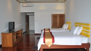 A hotel room with a wooden bed, a television on a wooden cabinet, and a large window with a view of the sky. - Myanmar Life Hotel (Yangon)