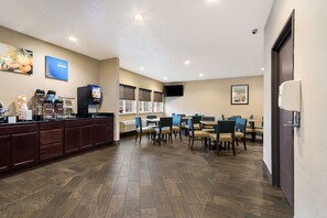 A hotel lobby with a reception desk, seating area, and a large screen. - Comfort Inn Yankton SD (Yankton)