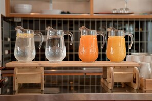 Cuatro jarras sobre un soporte de madera, dos con hielo y dos con bebidas.