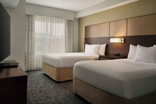 A hotel room with two beds, a TV, a bedside table, and a window with curtains. - Residence Inn by Marriott Savannah Airport (Pooler)