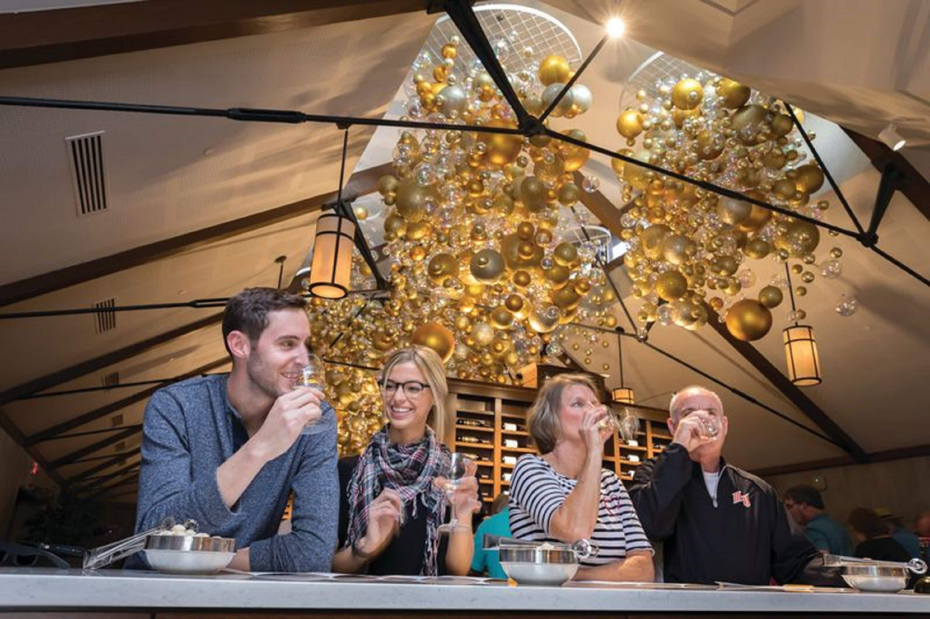 A group of people dining in a restaurant with a unique ceiling design featuring spherical decorations.