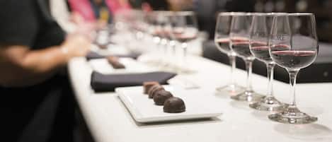Un evento de degustación con copas de vino y muestras de chocolate sobre una mesa.