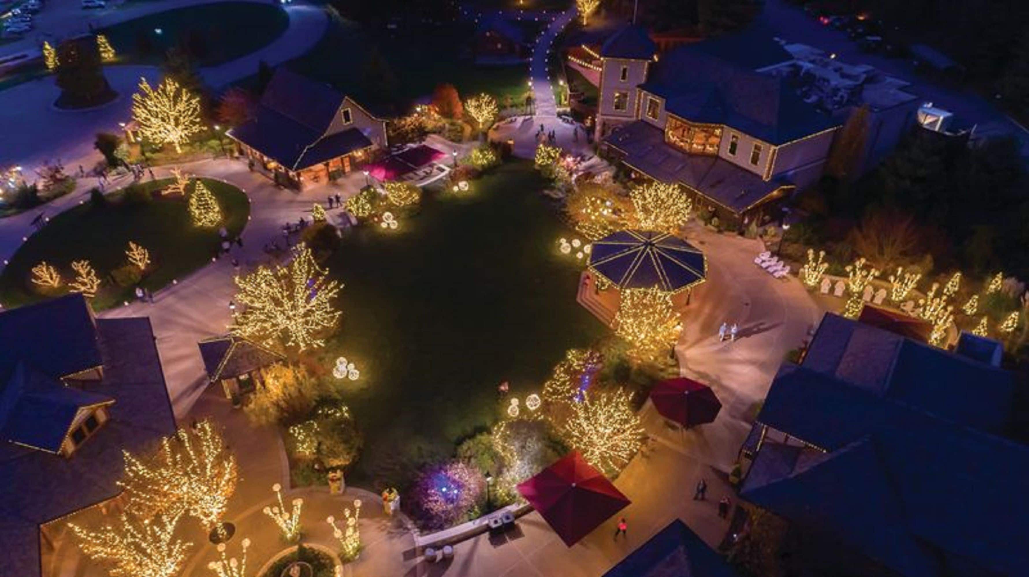 An aerial view of a residential area with houses, trees, and a central open space with a gazebo.