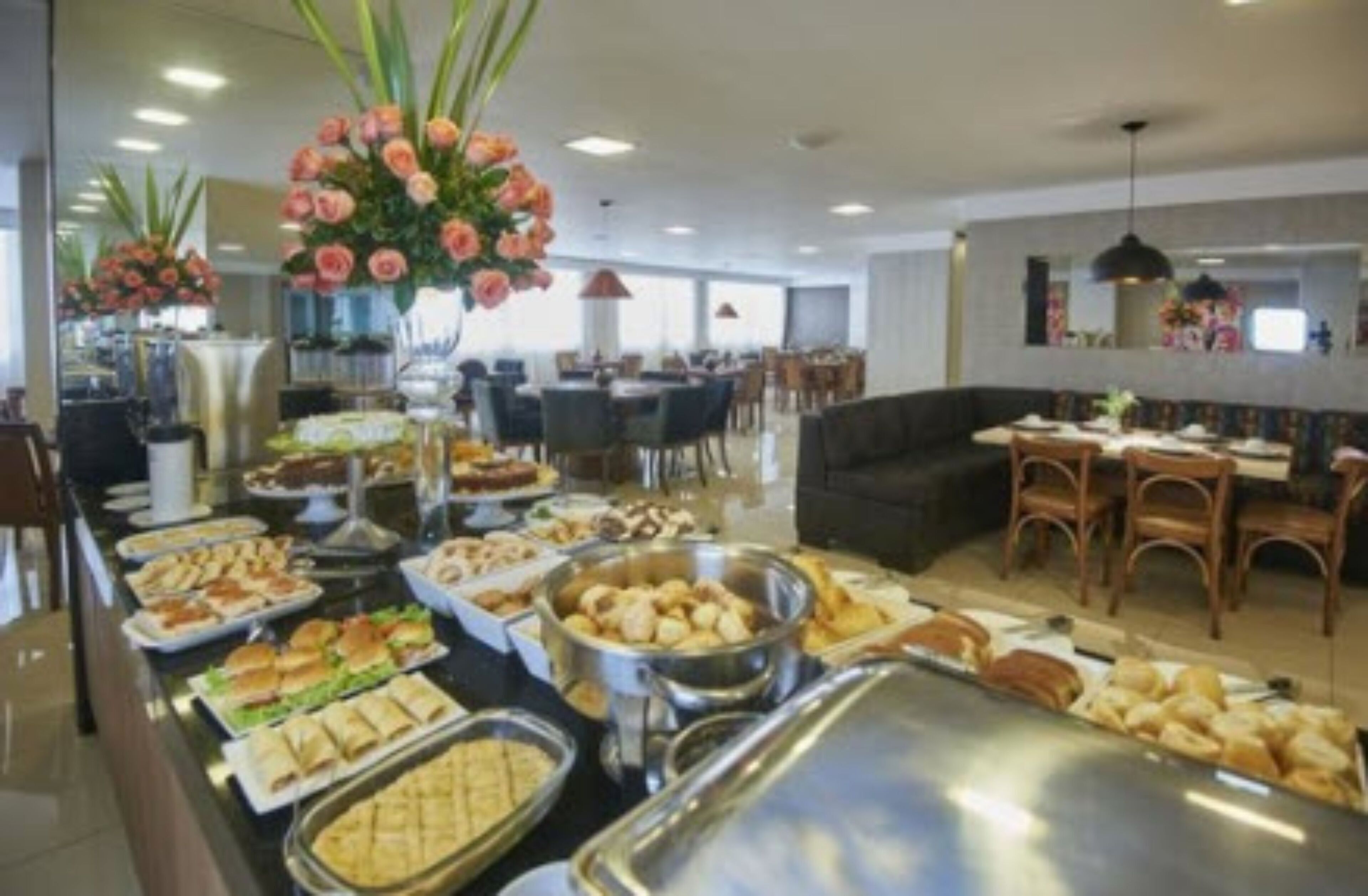 A buffet area with various food items and a seating area with tables and chairs.