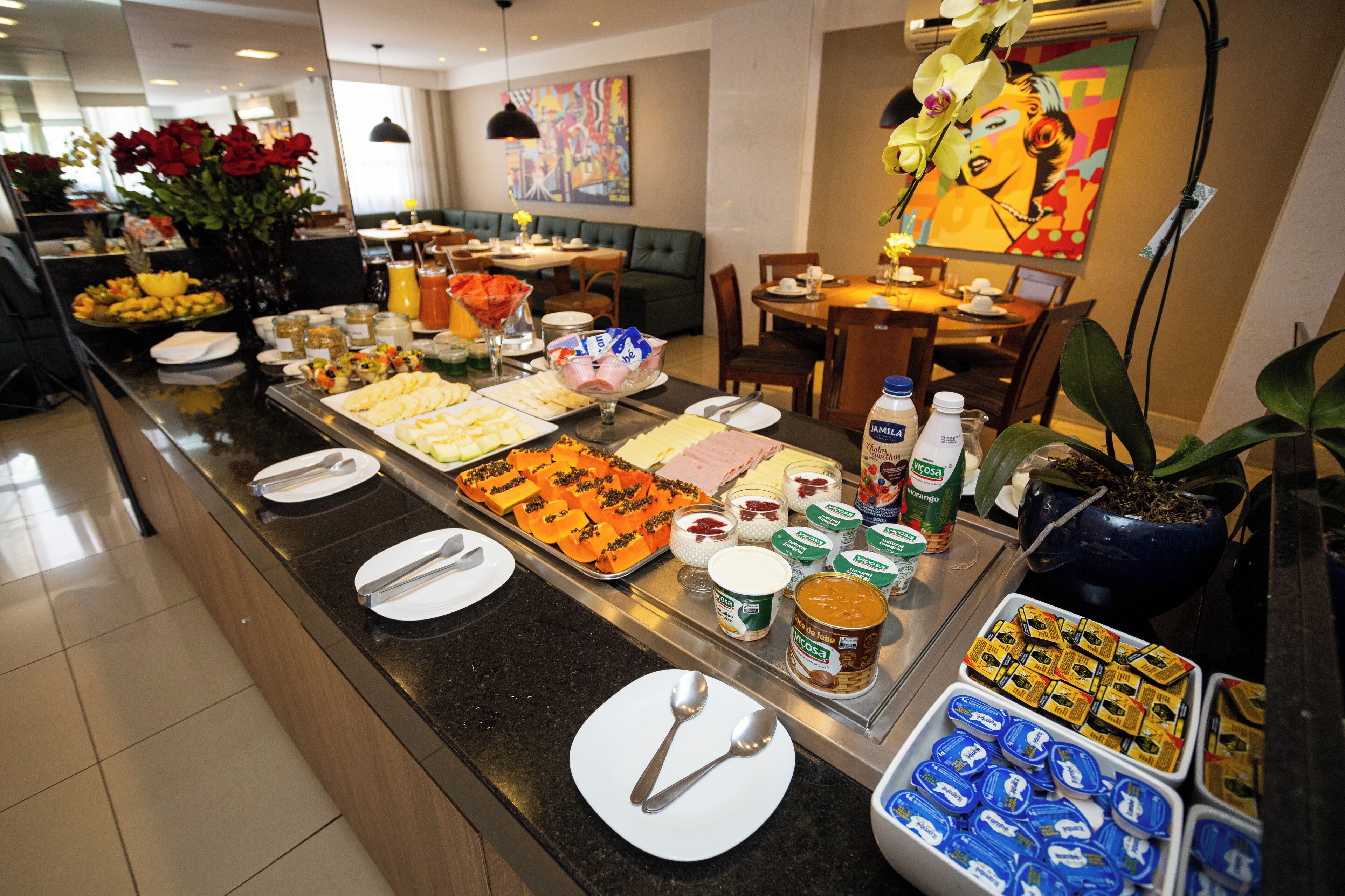 Un buffet proposant une variété de plats, notamment des fruits, des pâtisseries et des condiments.