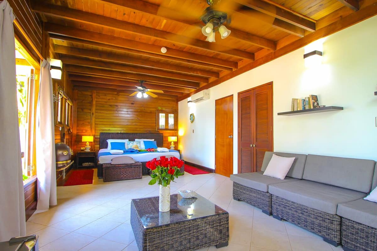A cozy room with a bed, a sofa, a coffee table, and a fireplace.
