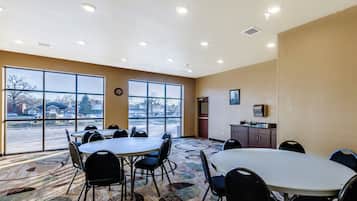 Un salón de conferencias con amplias ventanas, un reloj y una kitchenette.