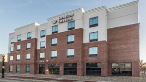 A Cobblestone Inn & Suites building with a modern brick facade, multiple windows, and a clear sky. - Cobblestone Inn & Suites - Waverly (Waverly)