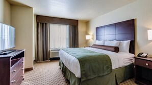 A hotel room with a bed, a desk, a lamp, and a telephone. - Cobblestone Inn & Suites - Waverly (Waverly)
