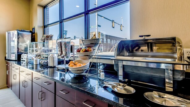 A modern kitchen with a large window, stainless steel appliances, and a variety of bowls and utensils on the counter. - Cobblestone Inn & Suites - Waverly (Waverly)