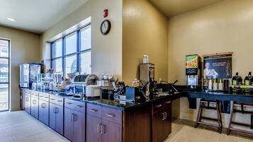 A modern kitchen with a large island, stainless steel appliances, and a clock on the wall.