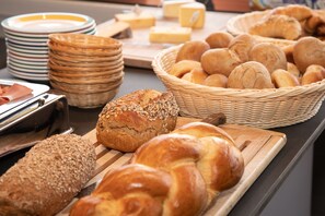 Una mesa de buffet con diferentes panes y quesos.
