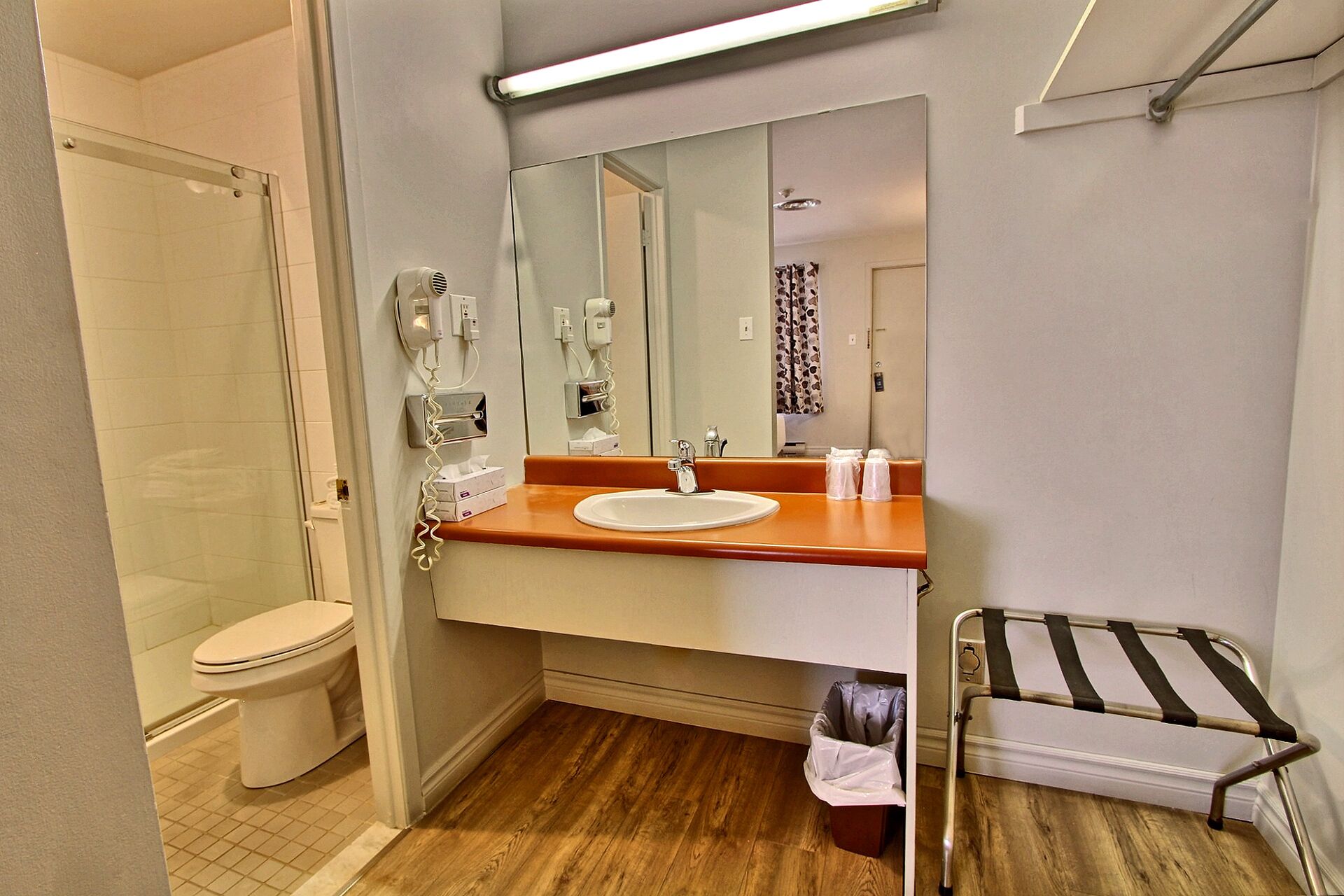A compact bathroom with a toilet, sink, and a mirror.