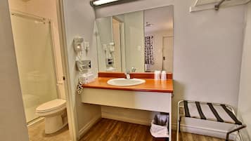 A compact bathroom with a toilet, sink, and a mirror.