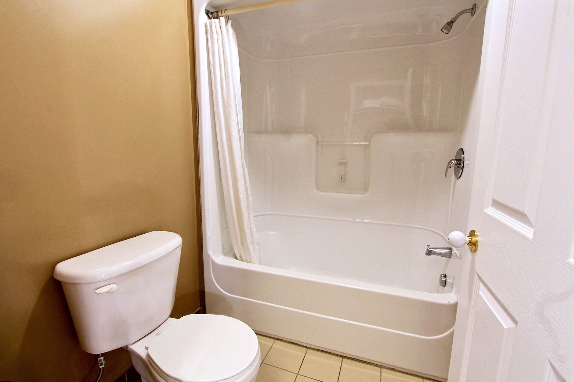 Un baño con inodoro, bañera y cortina de ducha.