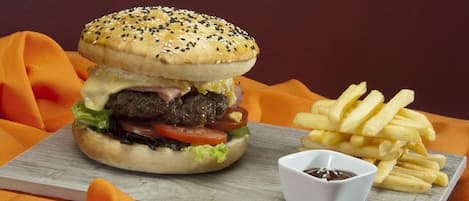 Hamburguesa con papas fritas y kétchup sobre una tabla de madera.
