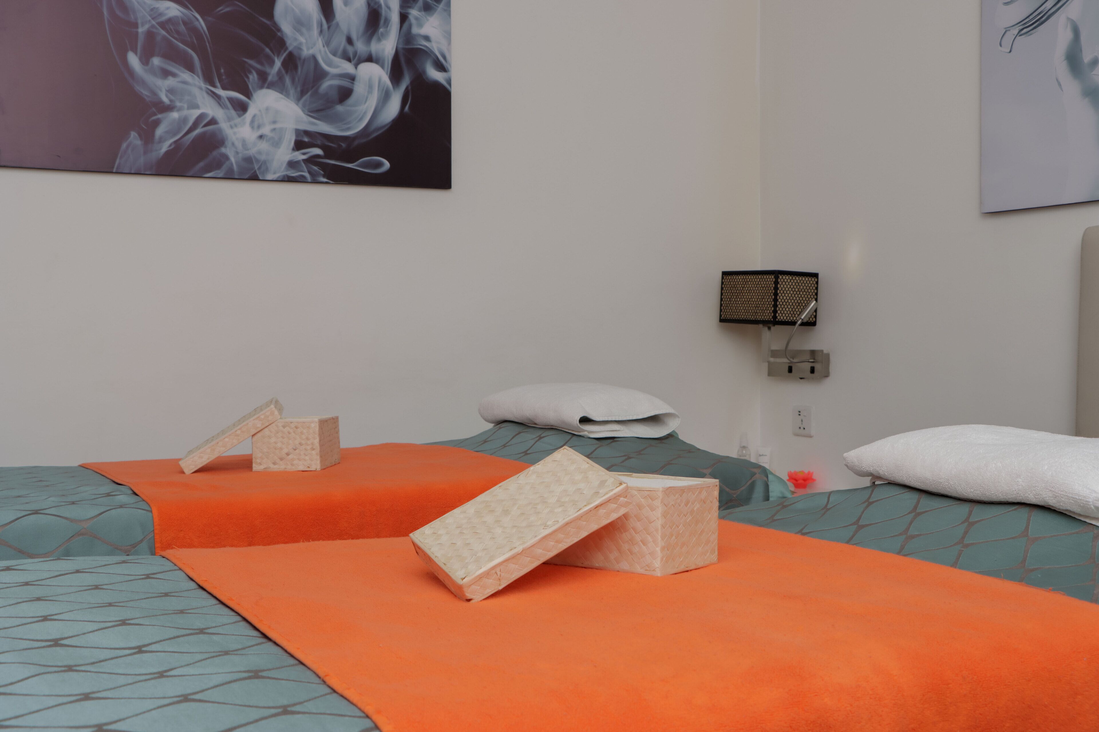 Una camera d'albergo con un letto, cuscini, una coperta e un purificatore d'aria a parete.