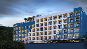 Un hotel de varios pisos con balcones, una terraza en la azotea y un letrero que indica que es un hotel Radisson.