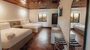 Una habitación de hotel con dos camas, un escritorio y una televisión.