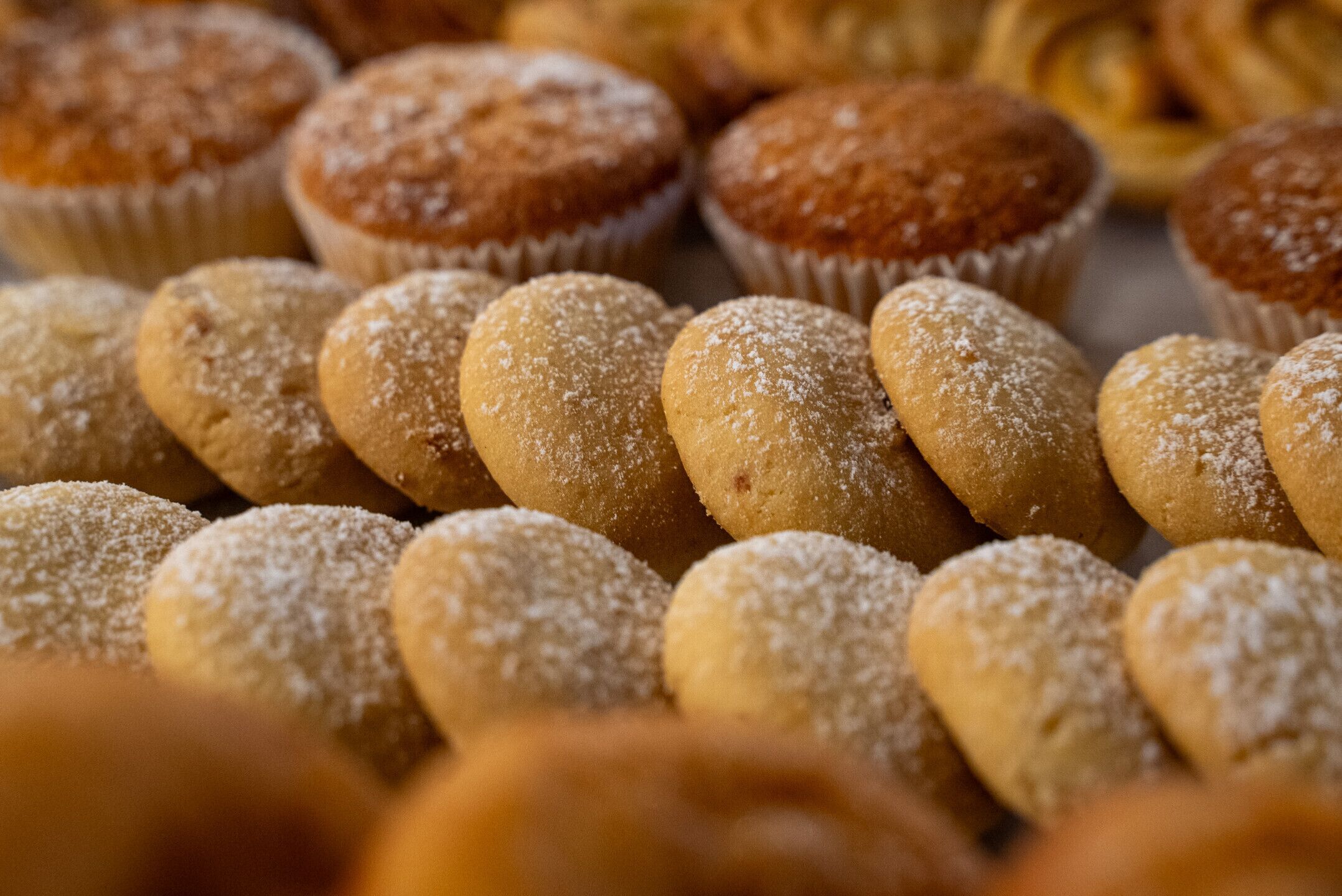 Une variété de produits de boulangerie, notamment des muffins et des biscuits, disposés les uns à côté des autres.