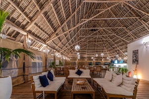 Un espacio interior con techo alto, mobiliario de madera e iluminación decorativa.