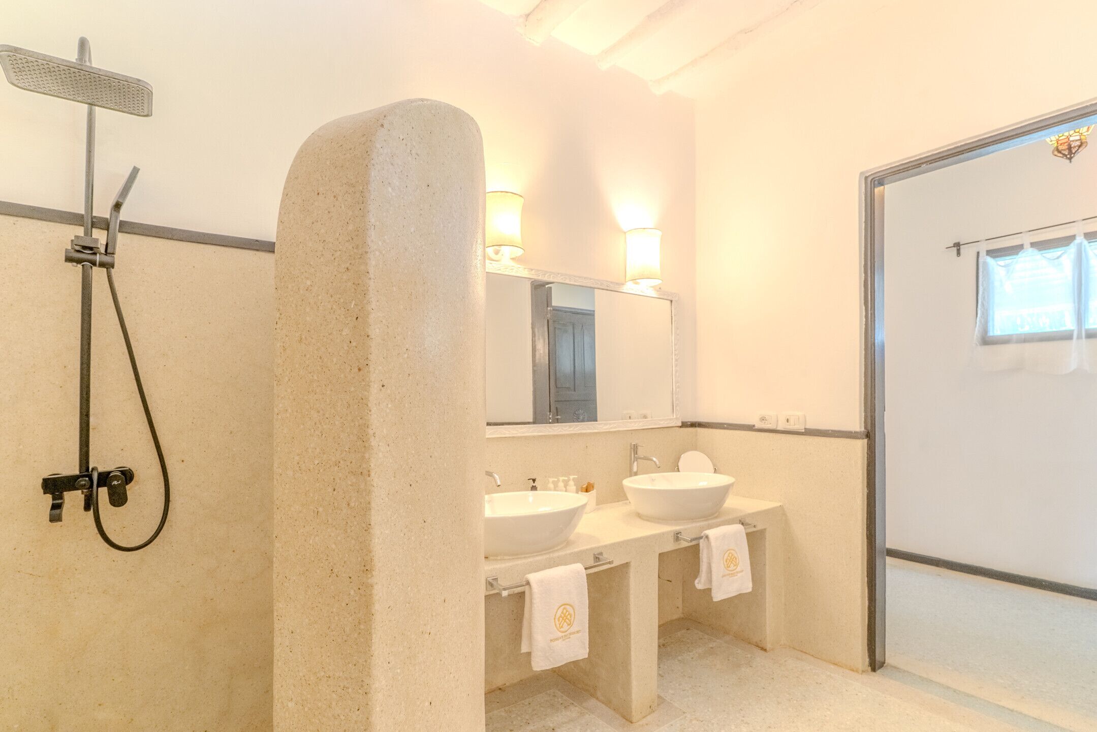 Une salle de bain avec une douche, deux lavabos, un miroir et un porte-serviettes.