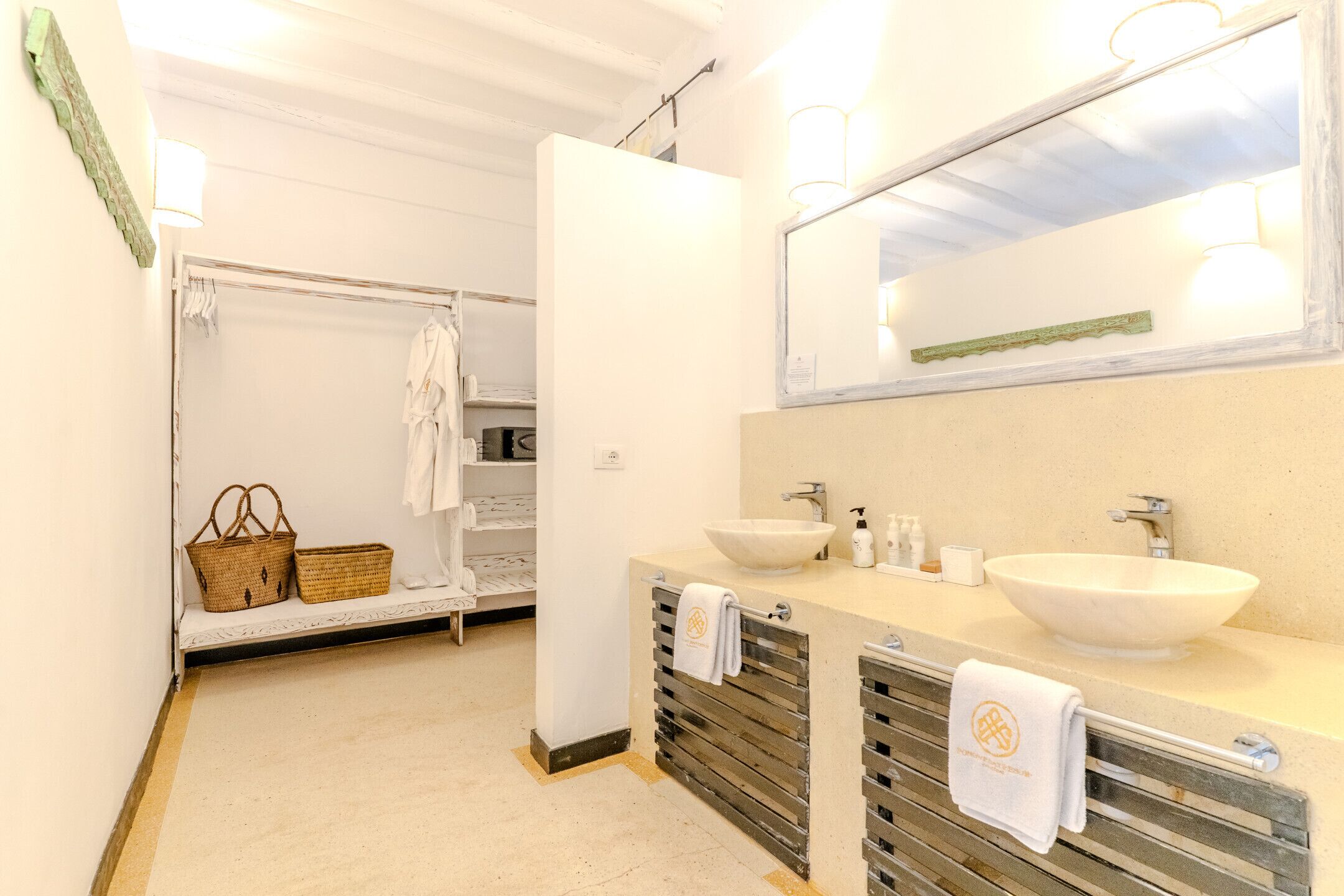 Une salle de bain avec une baignoire, deux lavabos, un miroir et un porte-serviettes.