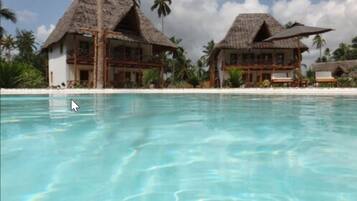 Una piscina al aire libre, sombrillas, sillones reclinables de piscina