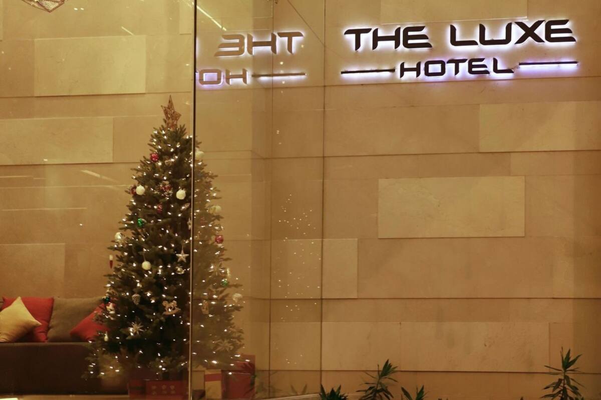 Un mur de verre orné d’un sapin de Noël et d’une enseigne indiquant « The Luxe Hotel ».