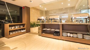 A modern restaurant with a buffet setup, including a wooden buffet counter and a glass partition. - Nicecy Ben Thanh Hotel (Ho Chi Minh City)