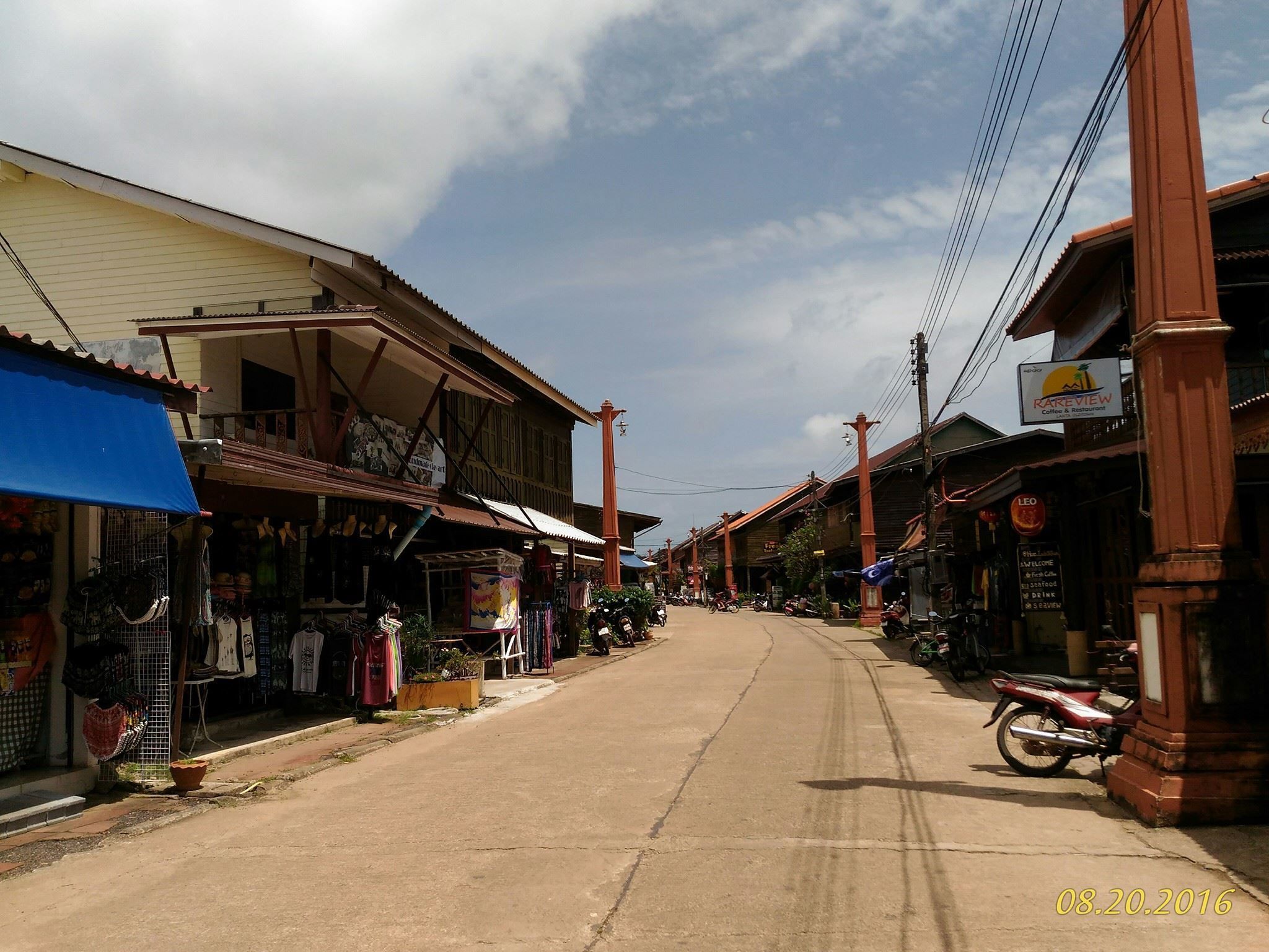 A street with buildings on both sides, some with signs and awnings.