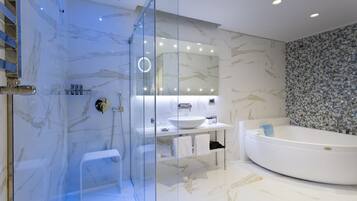 Un baño moderno con ducha de vidrio, lavamanos blanco y bañera grande.