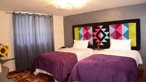 A hotel room with two beds, a large geometric wall art piece, a curtain, and a sunflower decoration. - Tocapu Boutique Hotel (Cusco)