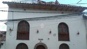 A white building with arched windows and a stone base, labeled "TOCAPU 889". - Tocapu Boutique Hotel (Cusco)