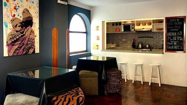 A modern kitchen with a bar area, a painting on the wall, and a chalkboard menu. - Tocapu Boutique Hotel (Cusco)