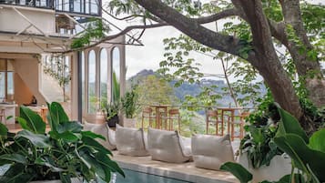 Ein Poolbereich mit Sitzgelegenheiten und Blick auf die Landschaft.
